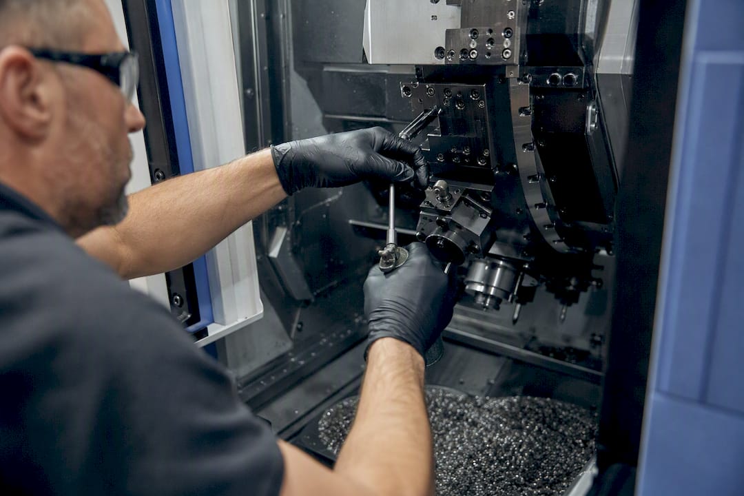 Technician hands maintaining CNC machine for repeatability